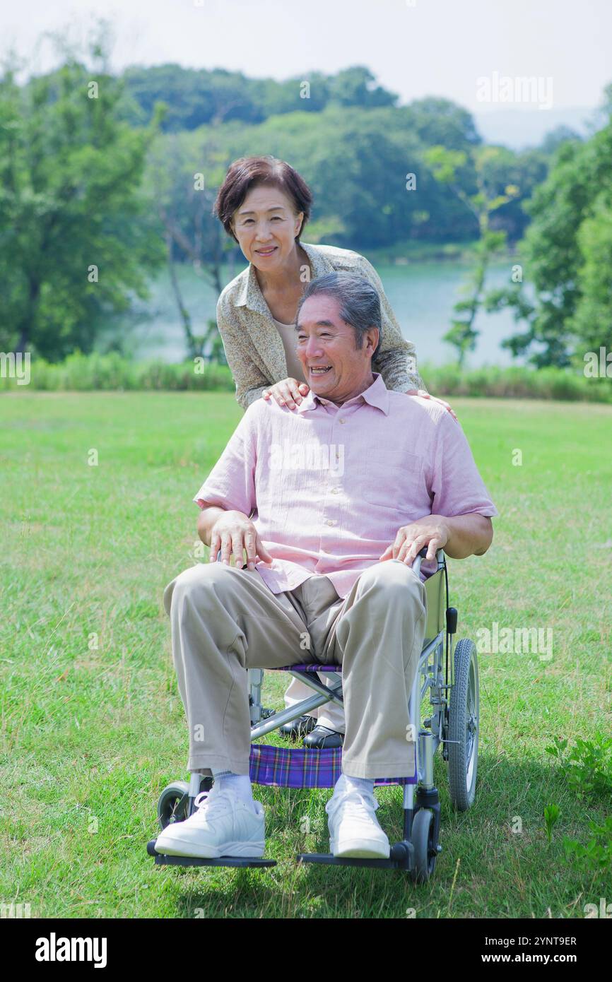 Pärchen, die im Rollstuhl laufen Stockfoto