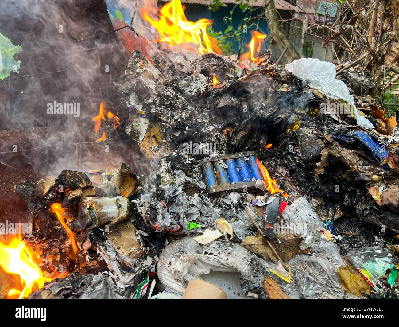 Verschmutzungsproblem auf den Philippinen: Geschmolzener Kunststoff und E-Abfall, verbrannte Elektronik im Hausmüll, Lithiumbatterie im Feuer, technische Mülldeponie, Deponie - Smartphone-aufgenommenes Stockfoto