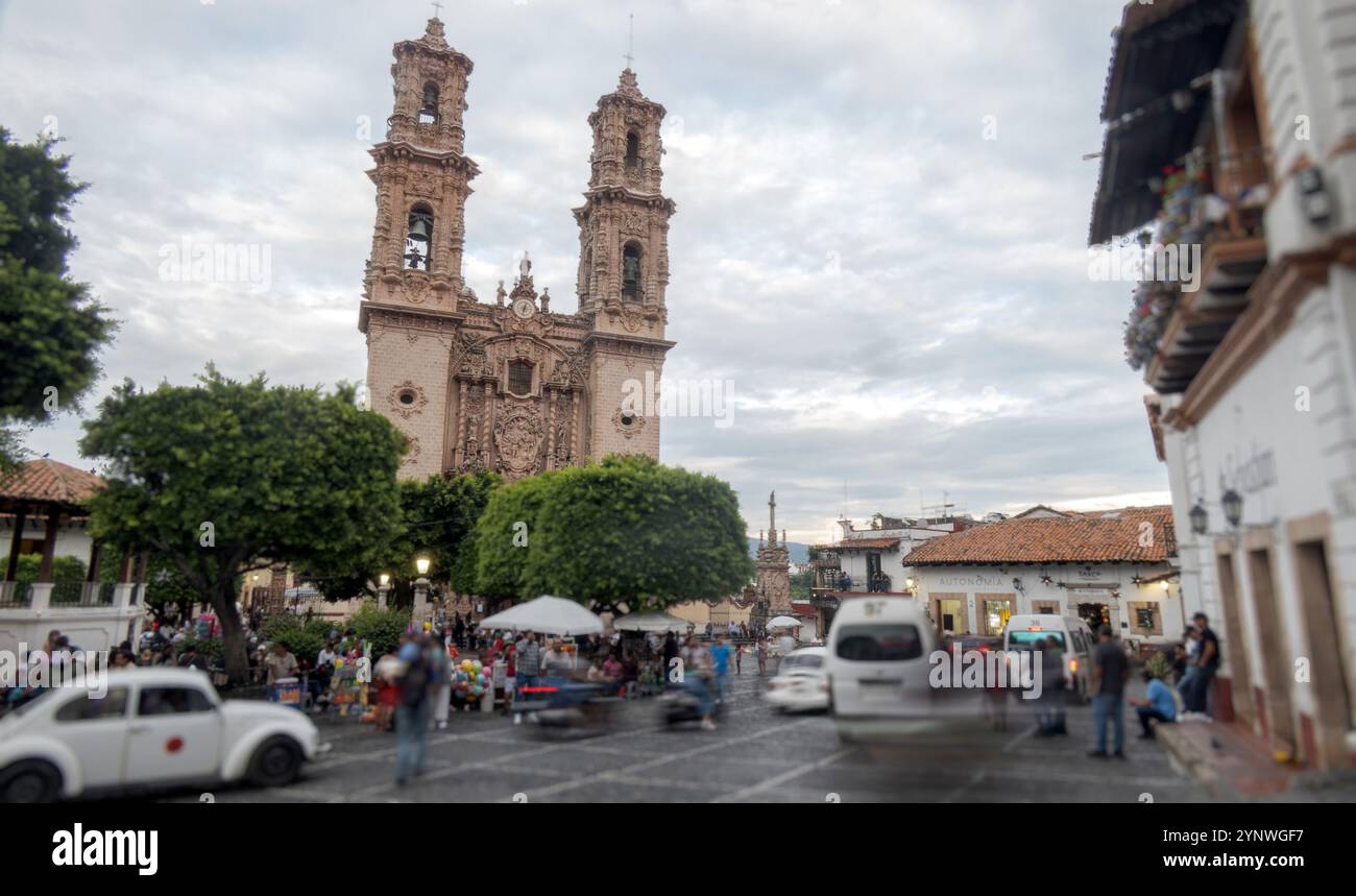 In der historischen Stadt Taxco de Alarcon, Mexiko, findet ein abendliches Treffen mit Einheimischen und Besuchern statt, die sich um den zentralen Platz mischen. Überragend ein Stockfoto