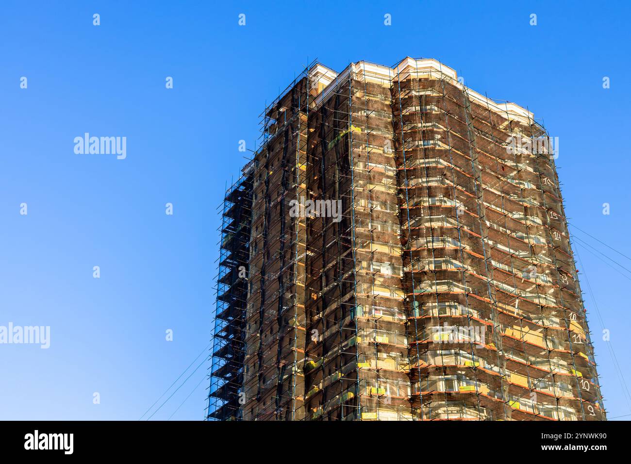 Sonnendurchflutetes Backsteinhochhaus, das bei Sonnenuntergang im Herbst renoviert wird Stockfoto