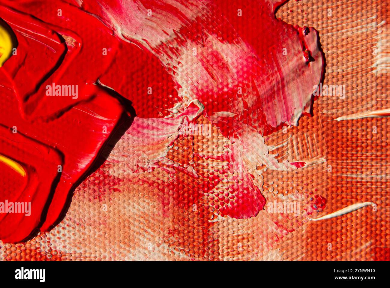 Strukturierte Acrylschichten aus roter, gelber und weißer Farbe schaffen eine ausdrucksstarke und farbenfrohe Leinwand. Stockfoto