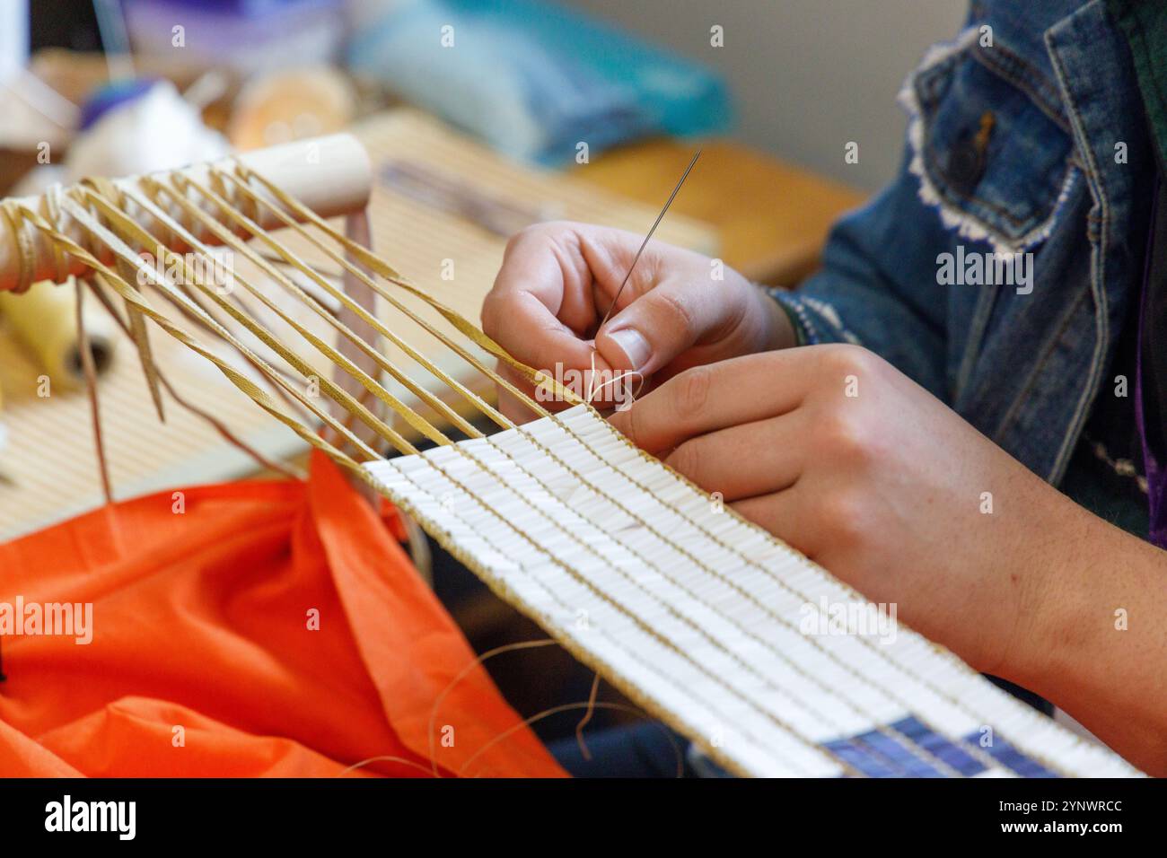 Ein einheimischer Handwerker, der einen Wampumgürtel an der Ganondagan State Historic Site in Victor, NY, erstellt. Stockfoto
