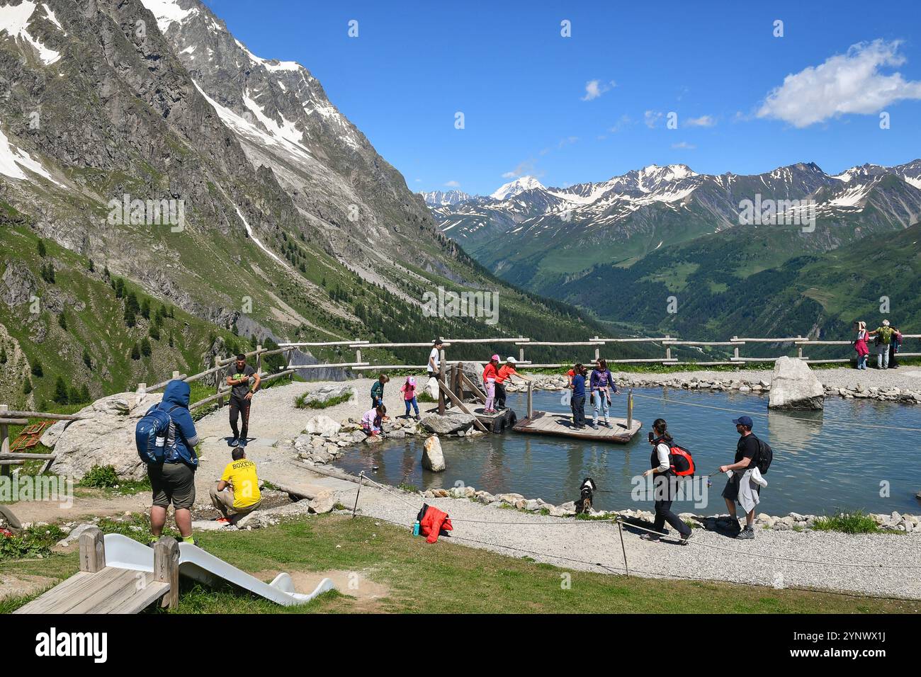 Menschen, die Spaß haben, einen Teich auf einem Floß an der Seilbahnstation Pavillon (2173 m) des Skyway Monte Bianco im Sommer, Courmayeur, Aosta, Italien zu überqueren Stockfoto