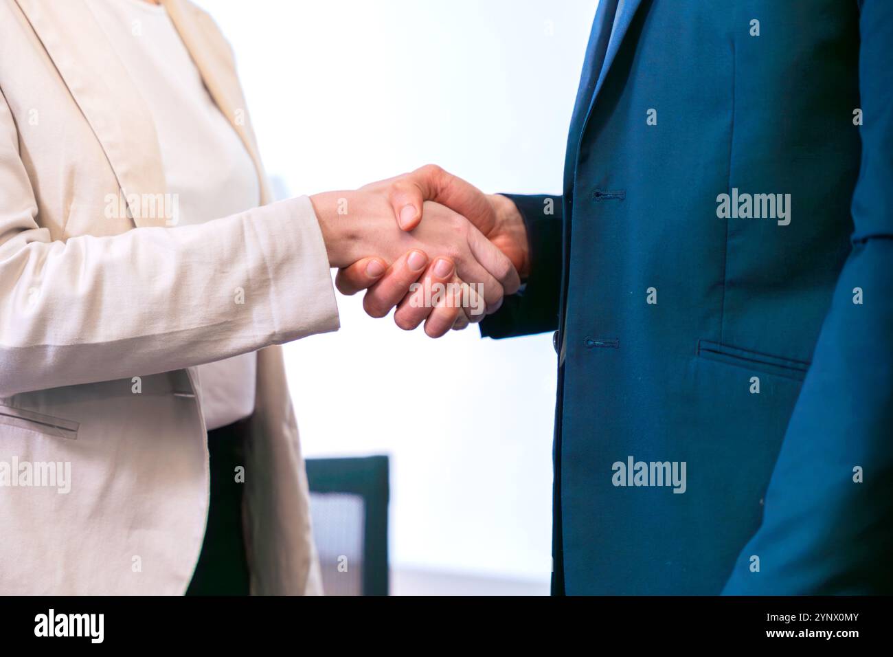 Geschäftsleute schütteln sich die Hände in modernen Büroumgebungen. Stockfoto