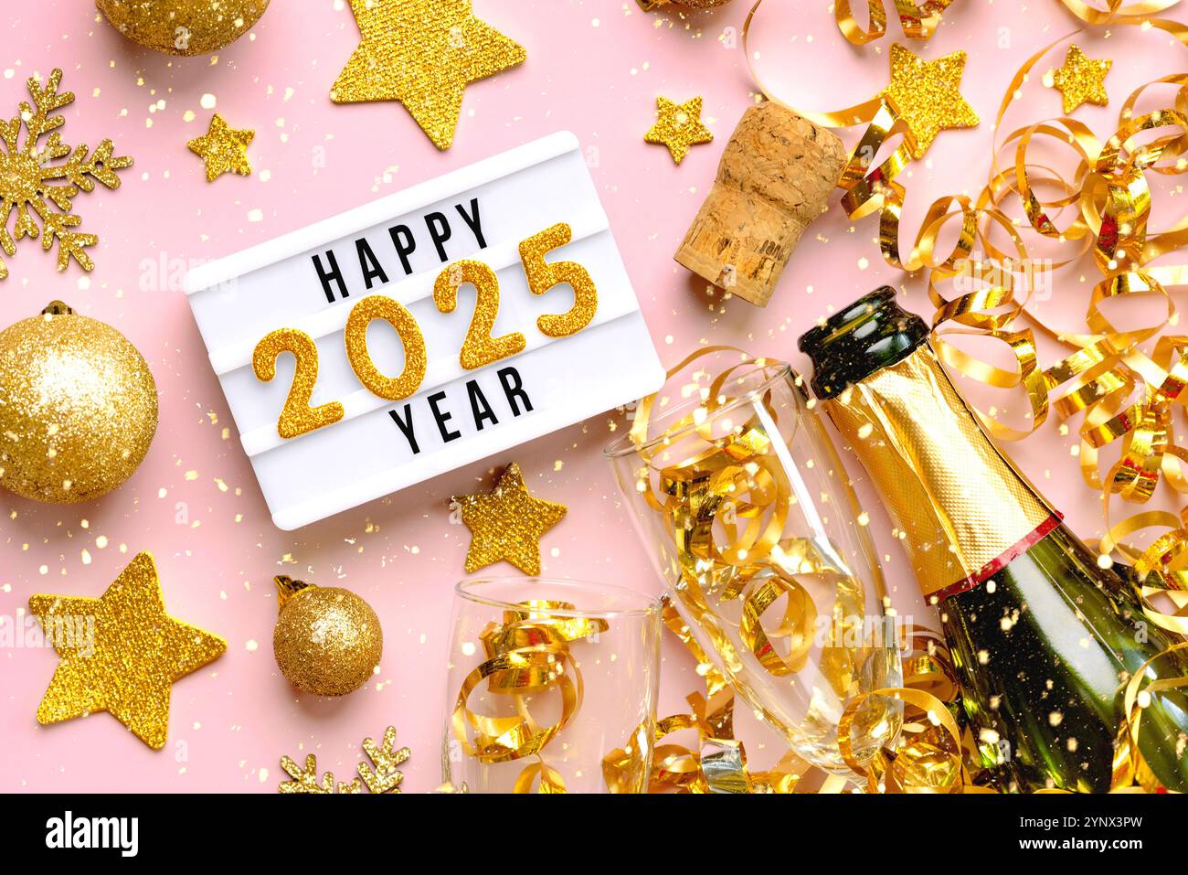 Happy New Year 2025. Top Blick auf Leuchtkasten mit dem Wort Happy Year 2025, goldene weihnachtskugeln, Kristallgläser und Champagnerflasche über rosa Hintergrund Stockfoto