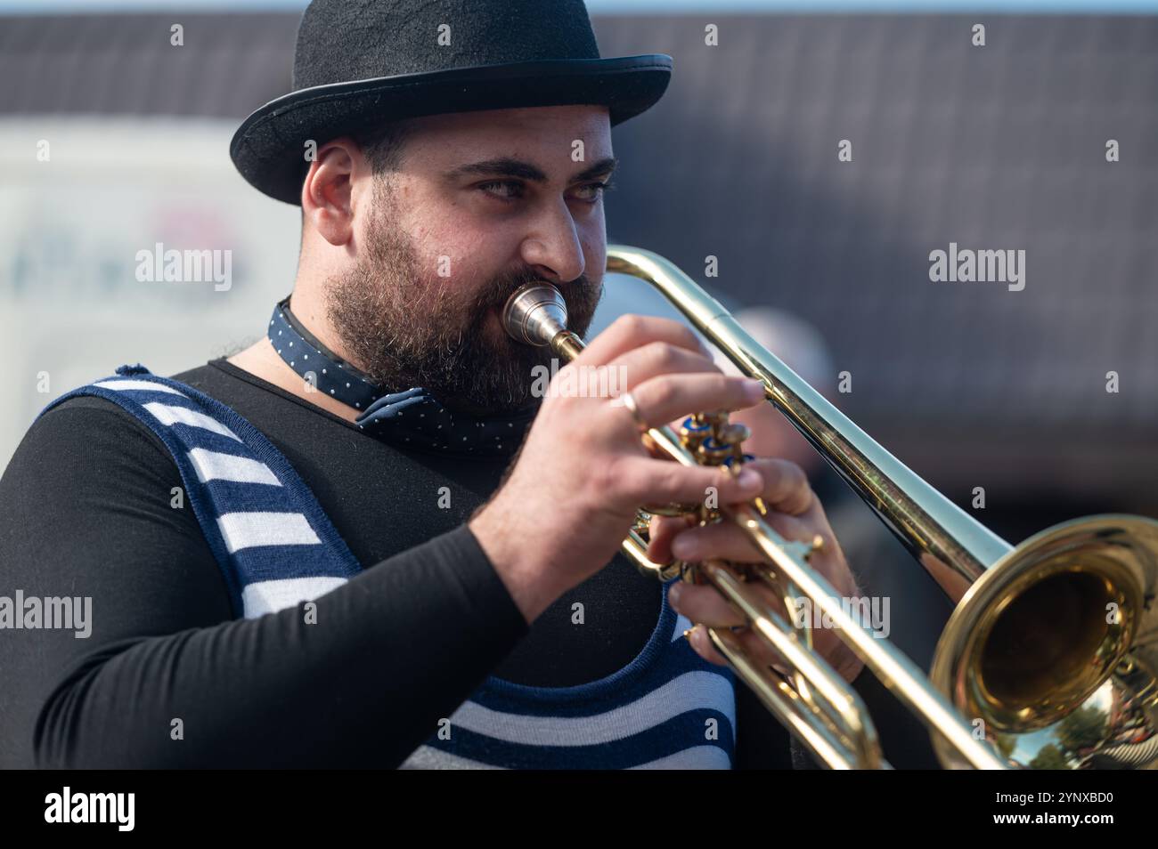 Tukums, Lettland - 28. August 2024: Ein Musiker tritt begeistert mit einer Trompete auf und zieht ein Outdoor-Publikum an. Stockfoto
