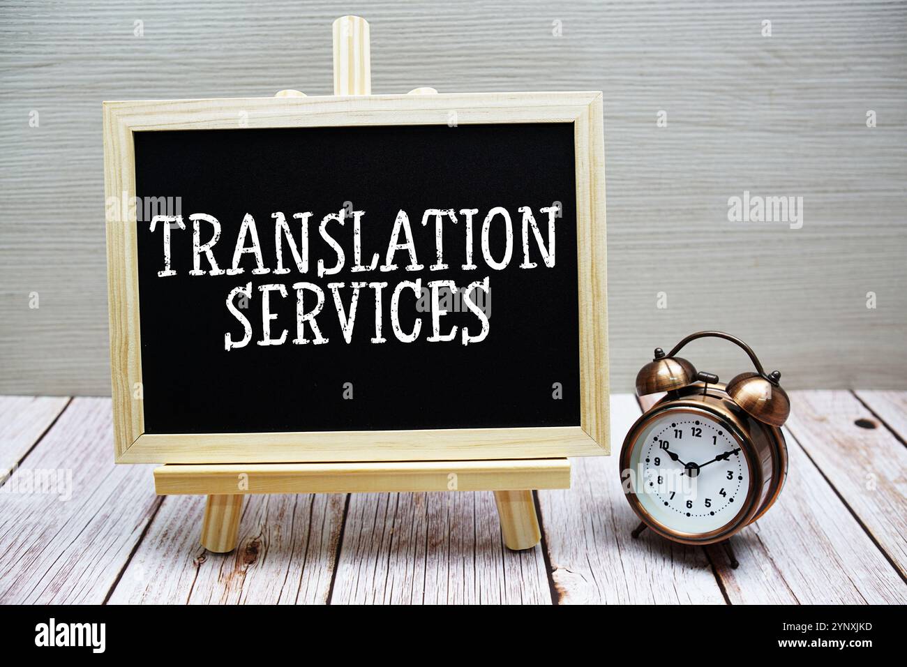 Text auf Tafel geschrieben mit Wecker auf hölzernem Hintergrund Stockfoto