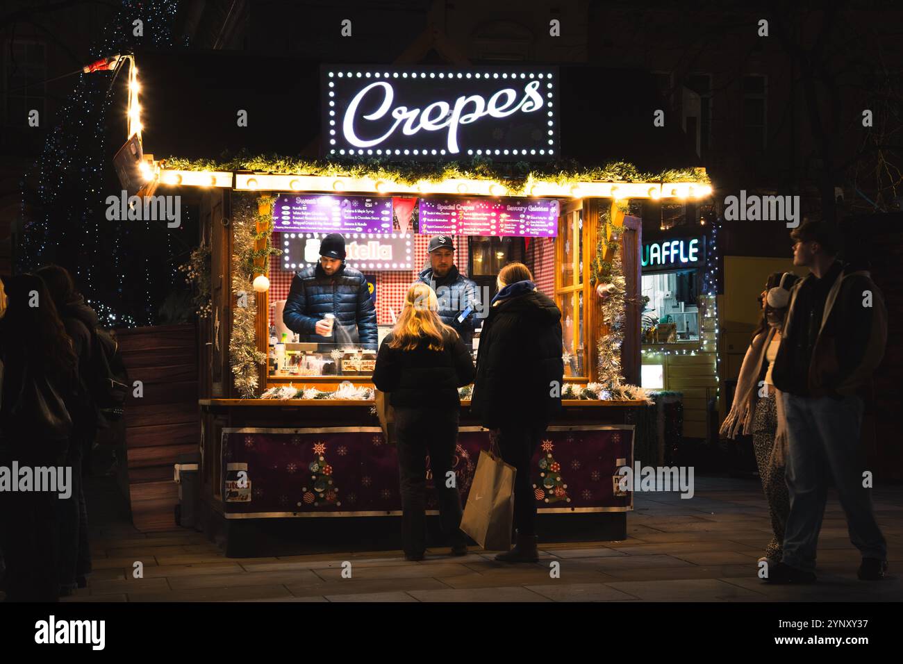 CITY SQUARE, LEEDS, GROSSBRITANNIEN - 25. NOVEMBER 2024. Ein farbenfroher Marktstand, der Crepes an Käufer verkauft, auf dem Leeds Christmas Market am City Square, Leeds, Stockfoto