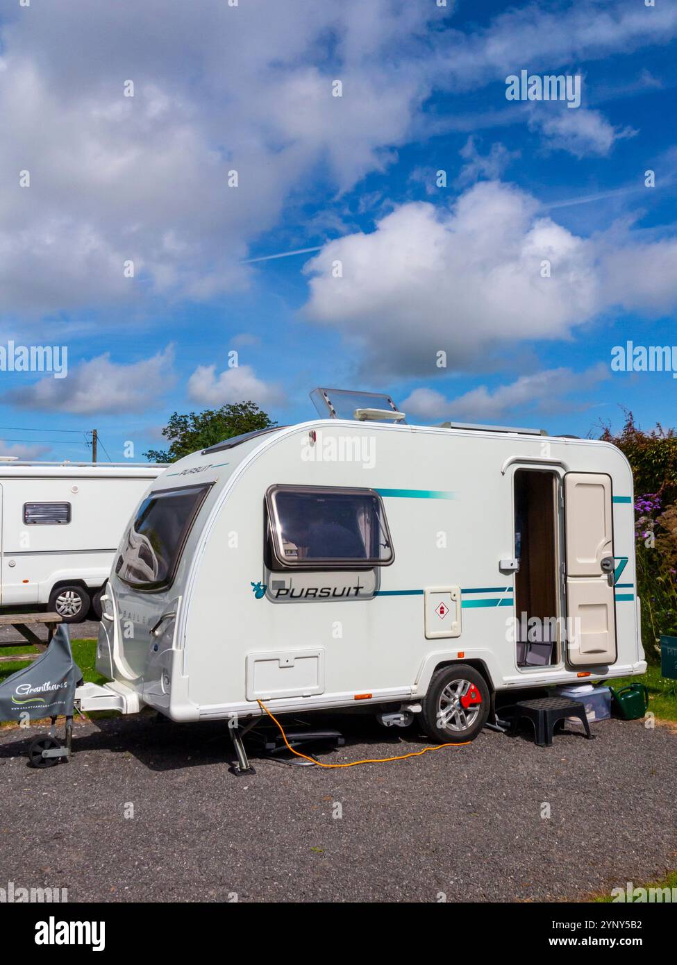 Bailey Pursuit 400-2 Tourenwagen mit zwei Liegeplätzen auf einem Platz auf einem Wohnwagenplatz im Sommer mit blauem Himmel und Wolken darüber. Stockfoto