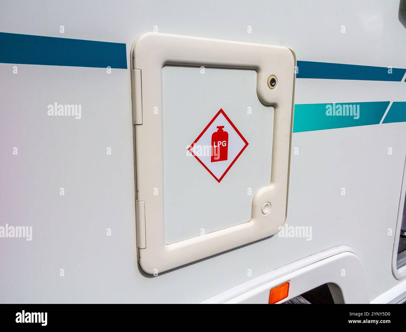 Flüssiggas-Symbol an der Tür eines Tankladens auf einem Tourenwagen mit Aufklebern auf beiden Seiten. Stockfoto