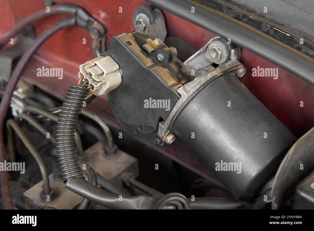 Nahaufnahme des schwarzen Scheibenwischermotors des Autos, Elektromotor mit Schaltmechanismus, der mit dem Softfokus im Motorraum verbunden ist Stockfoto