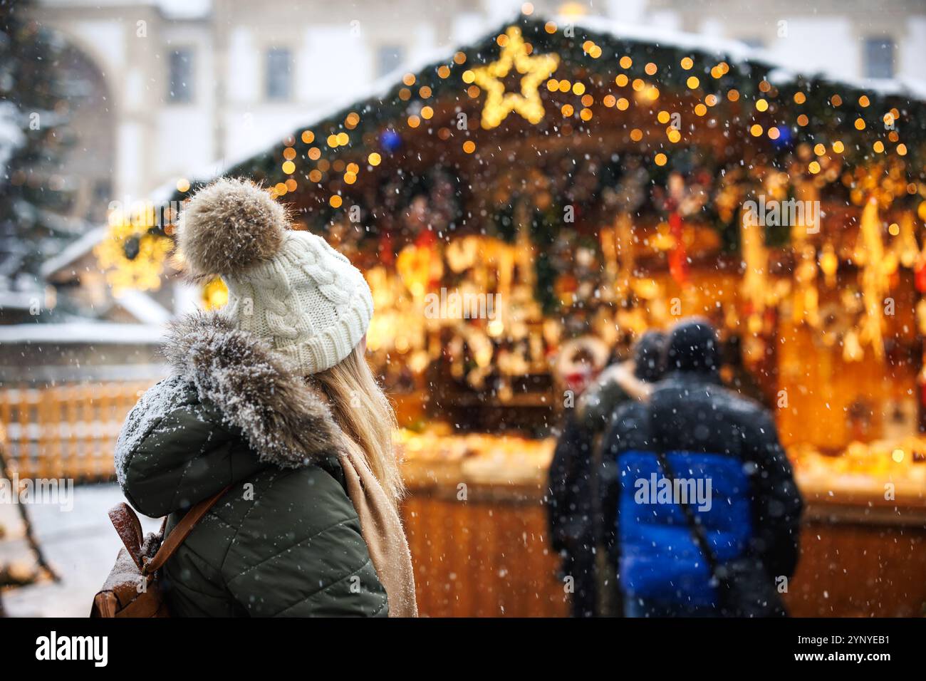 Frau genießt den Weihnachtsmarkt in der Stadt während der Adventsferien. Weihnachtsbeleuchtung am Marktstand Stockfoto