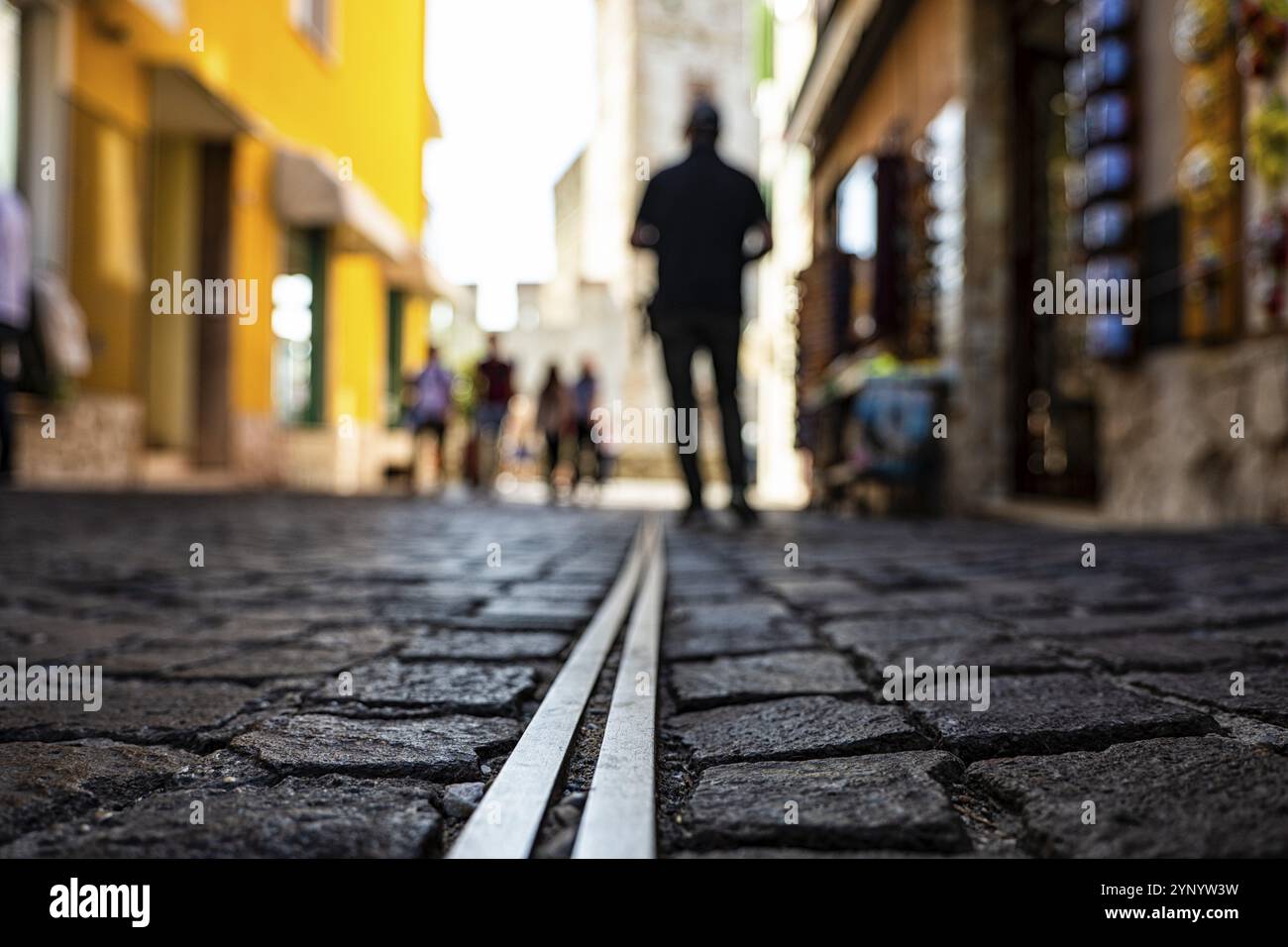 Blick von unten auf einen Mann, der in einer Gasse der Stadt Sirmione spaziert Stockfoto