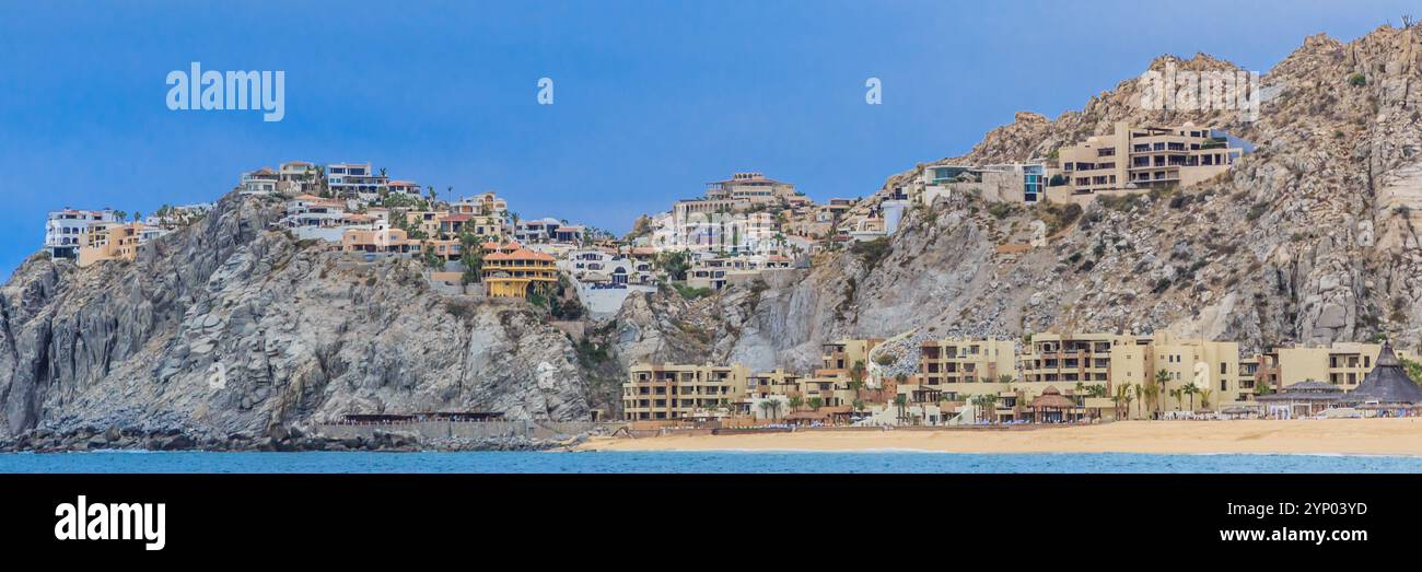 Ein wunderschöner Strand mit einem Berg im Hintergrund. Der Strand ist voller Menschen und die Häuser sind sehr schön Stockfoto