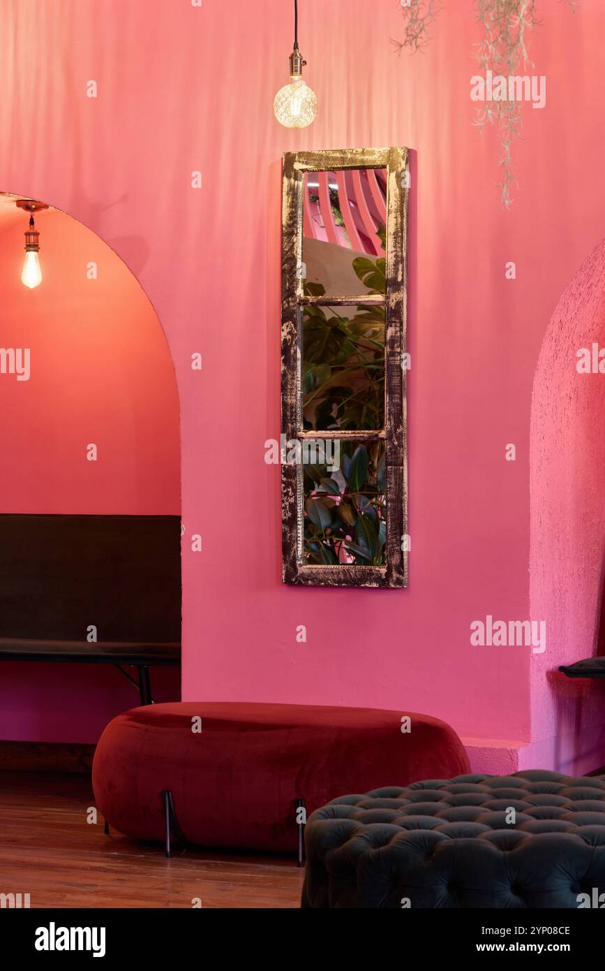 Diese bezaubernde rosafarbene Inneneinrichtung besticht durch eine stilvolle Einrichtung, die durch einen wunderschönen Spiegel ergänzt wird Stockfoto