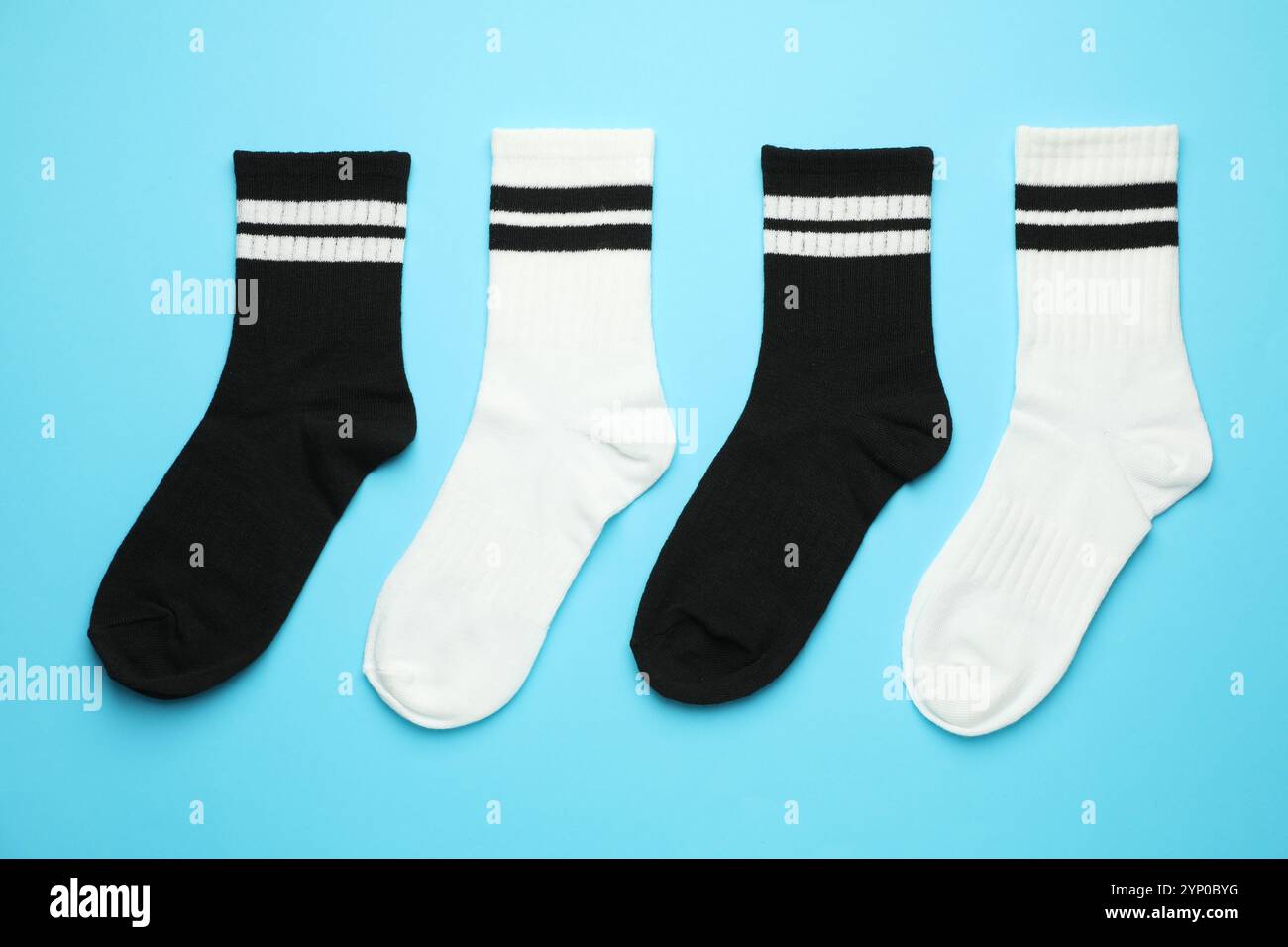 Verschiedene weiche Socken auf hellblauem Hintergrund, flach geschnitten Stockfoto