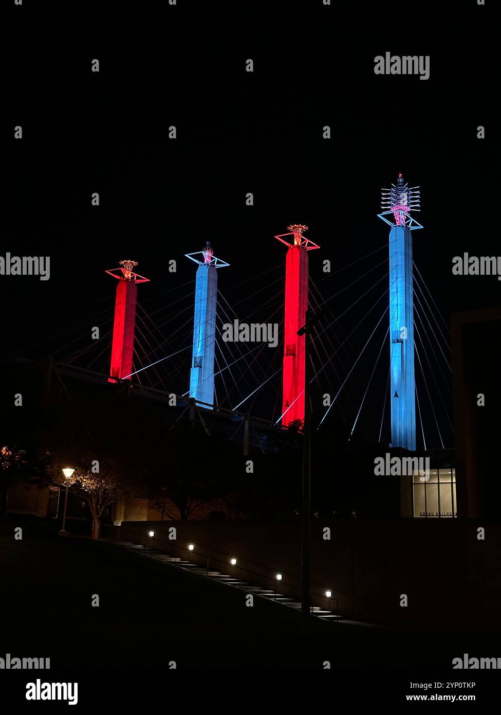 Erleben Sie die lebendige Schönheit von Kansas City bei Nacht mit diesem atemberaubenden Bild der Bartle Sky Stationen, die in auffälligen Blau- und Rottönen beleuchtet sind. - Smartphone-aufgenommenes Stockfoto