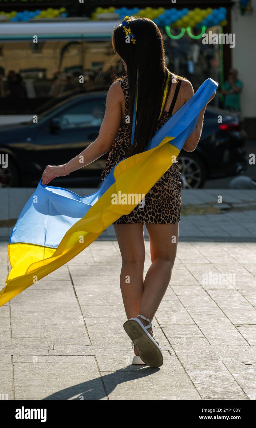 24.08.2024, Ukraine, Oblast Lemberg, Lemberg - Junge Frau posiert mit ukrainischer Flagge am Unabhängigkeitstag. Wegen Russland gibt es keine großen Ereignisse Stockfoto