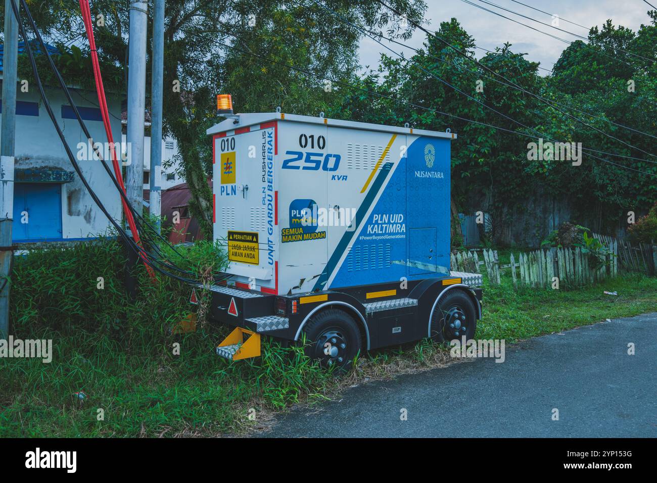 Balikpapan, Indonesien - 3. September 2024. Ein mobiler Transformator, der in einem Wohngebiet abgestellt ist und die umliegenden Häuser mit Strom versorgt. Stockfoto