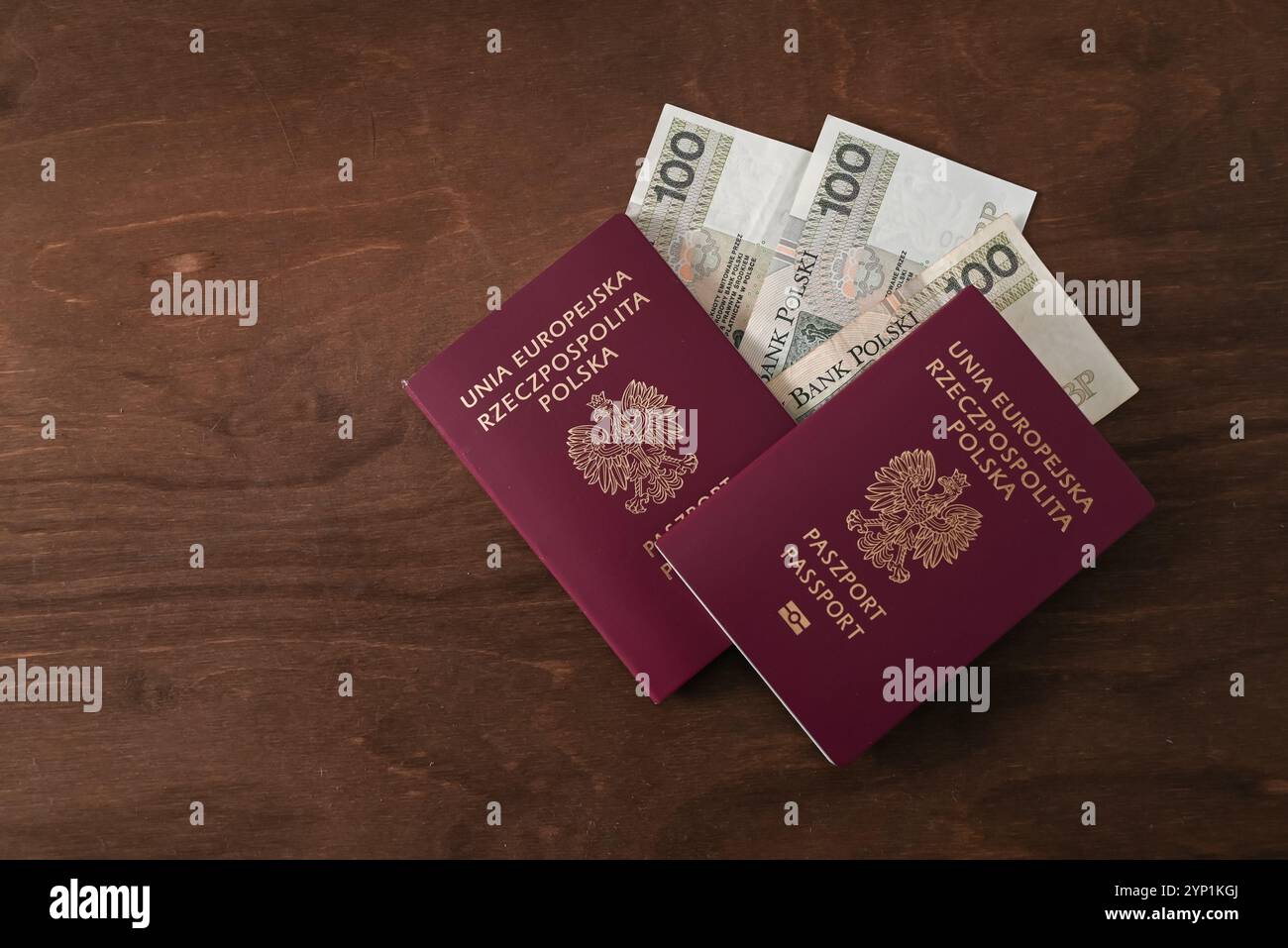 Pass "Republik Polen der Europäischen Union" und 100 PLN polnische Banknoten auf Holztisch Stockfoto