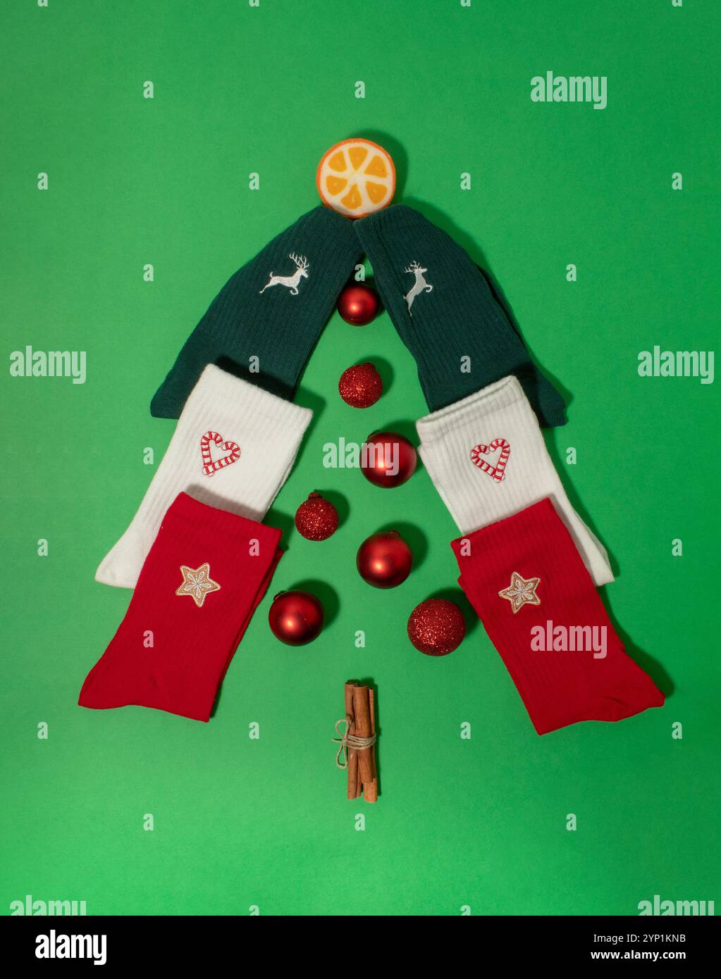 Weihnachtsbaum aus bunten Socken mit roten Weihnachtskugeln Stockfoto