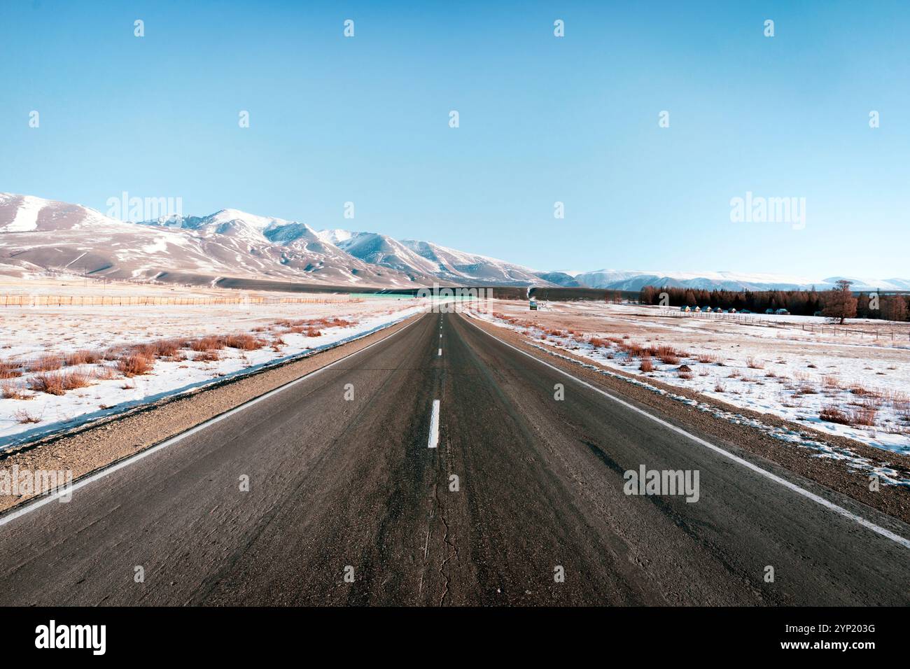 Bergauf Straßenlandschaft im Winter in Island. Asphaltstraße mit seitlich voller Schnee Stockfoto