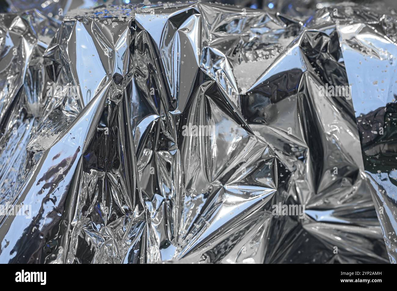 Zerknitterte, zerknitterte Silberfolie mit Schnee als Weihnachten, Neujahrsstruktur oder Hintergrund Stockfoto