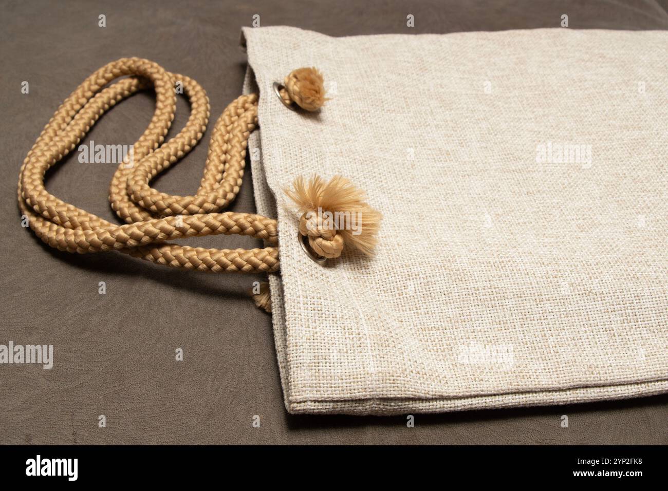 Strukturierte Jute Dot-Tasche auf dem Sofabett im Haus, geeignet für Seitenbeutel Produktmockup Stockfoto