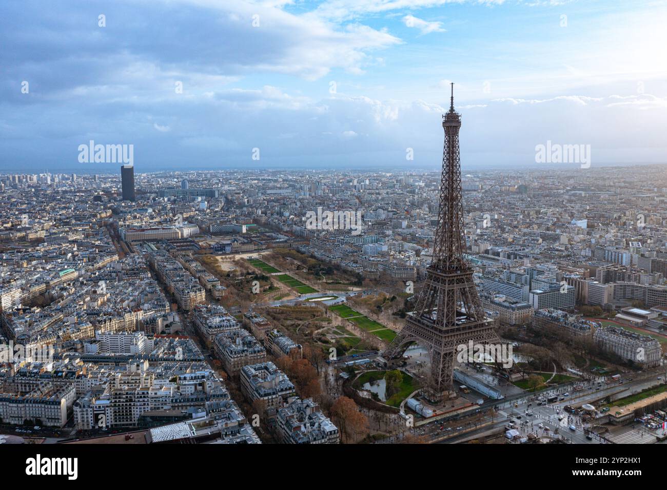 Atemberaubender Blick aus der Luft auf Paris mit dem berühmten Eiffelturm, umgeben von bezaubernden Stadtansichten und grünen Parks, unter einem dramatisch bewölkten Himmel Stockfoto