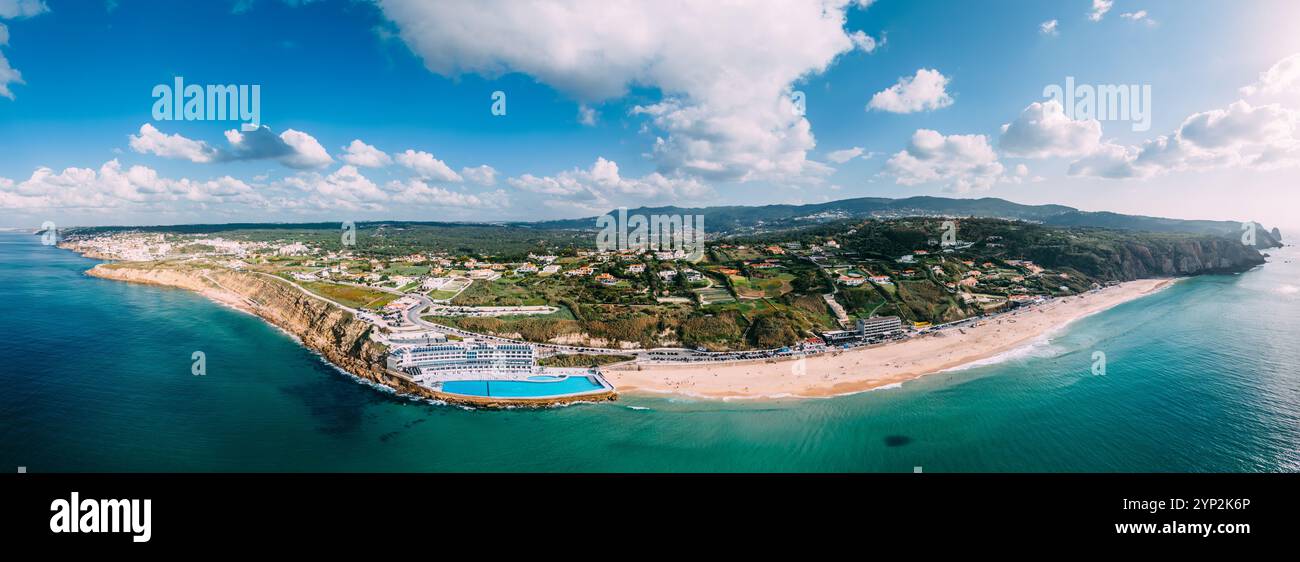 Panoramablick auf den weißen Sand von Praia Grande, dem größten Strand an der Sintra-Küste, mit dem Meerwasserpool des Arribas Hotels Stockfoto