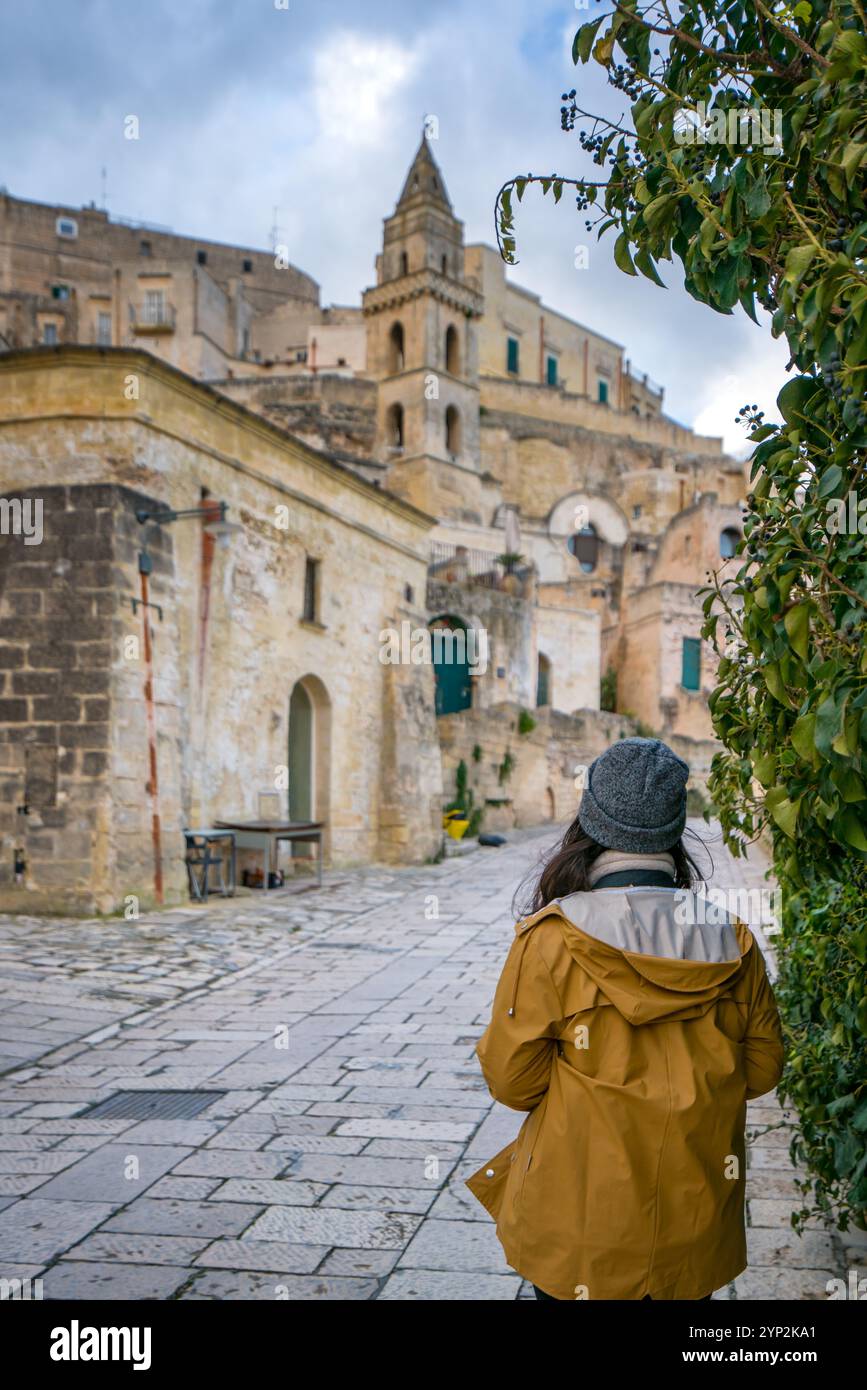 Rückblick einer Reisenden, die eine Steinkirche in der antiken Stadt Matera, Basilicata, Italien, Europa ansieht Stockfoto