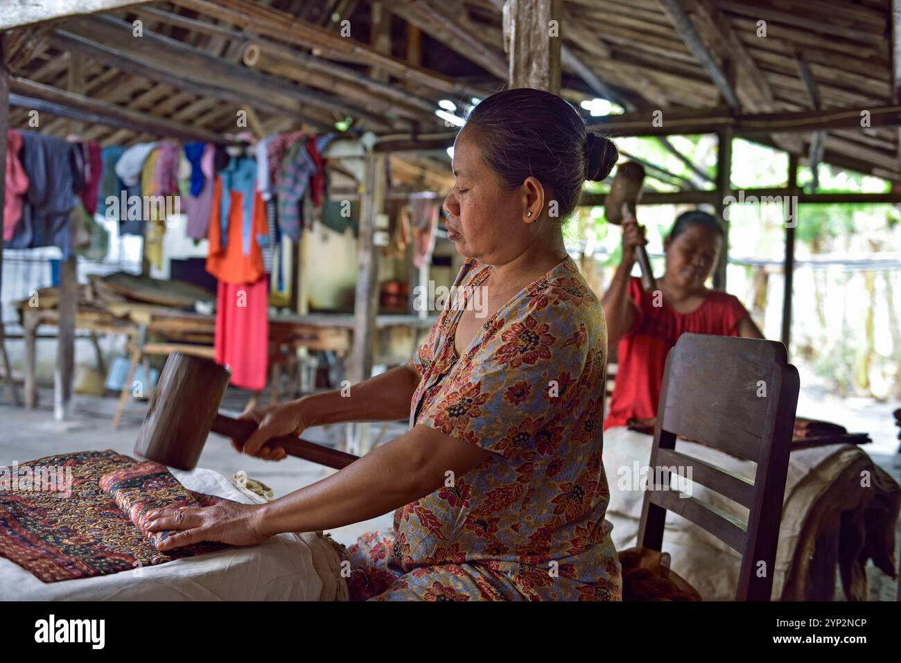 Frau, die einen Hammer zum Falten von Batikstoff benutzt, Nyah Kiok Batikhaus, handwerkliche Produktion von sieben Frauen seit über 30 Jahren, Lasem, Java Island, Indonesien Stockfoto