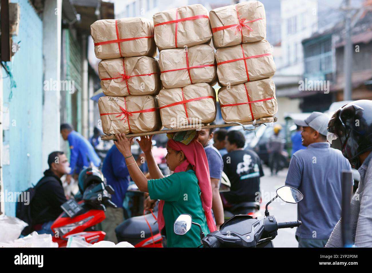 Täglicher Arbeiter auf dem traditionellen Lebensmittelmarkt, Frau mit schweren Taschen auf dem Kopf, Surabaya, Java, Indonesien, Südostasien, Asien Stockfoto