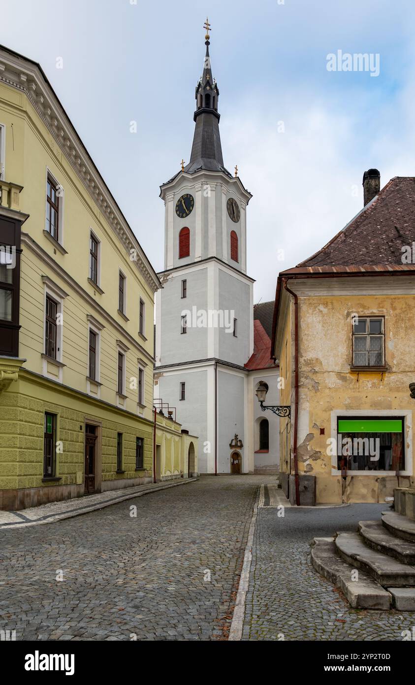 Ein atemberaubender Blick auf eine Kirche mit einem hohen Turm in der Stadt Kraliky, die ihre historische Architektur und ihre ruhige Präsenz vor dem Hintergrund von zeigt Stockfoto