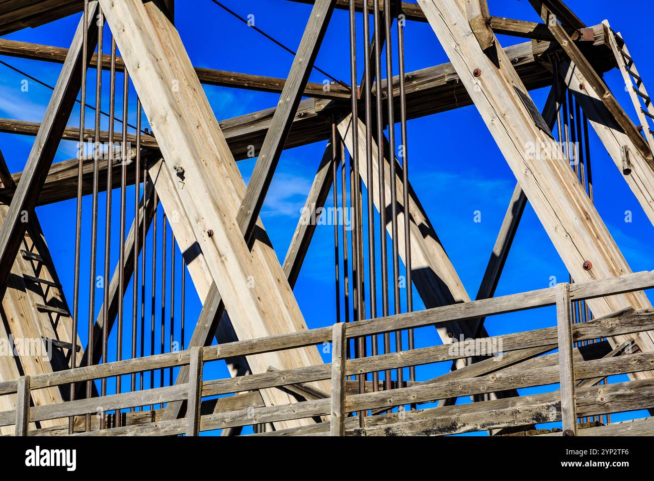 Eine Brücke mit blauem Himmel im Hintergrund. Die Brücke ist alt und hat ein rustikales Aussehen Stockfoto