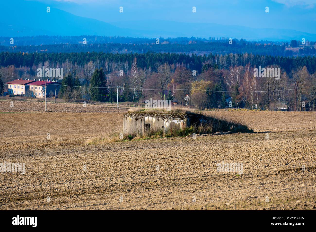 Ein historischer Blick auf einen tschechoslowakischen Anti-Infanterie-Bunker, bekannt als „Ropik“, der auf einem von Bäumen umgebenen Feld steht und an die Vergangenheit und seinen Wartim erinnert Stockfoto