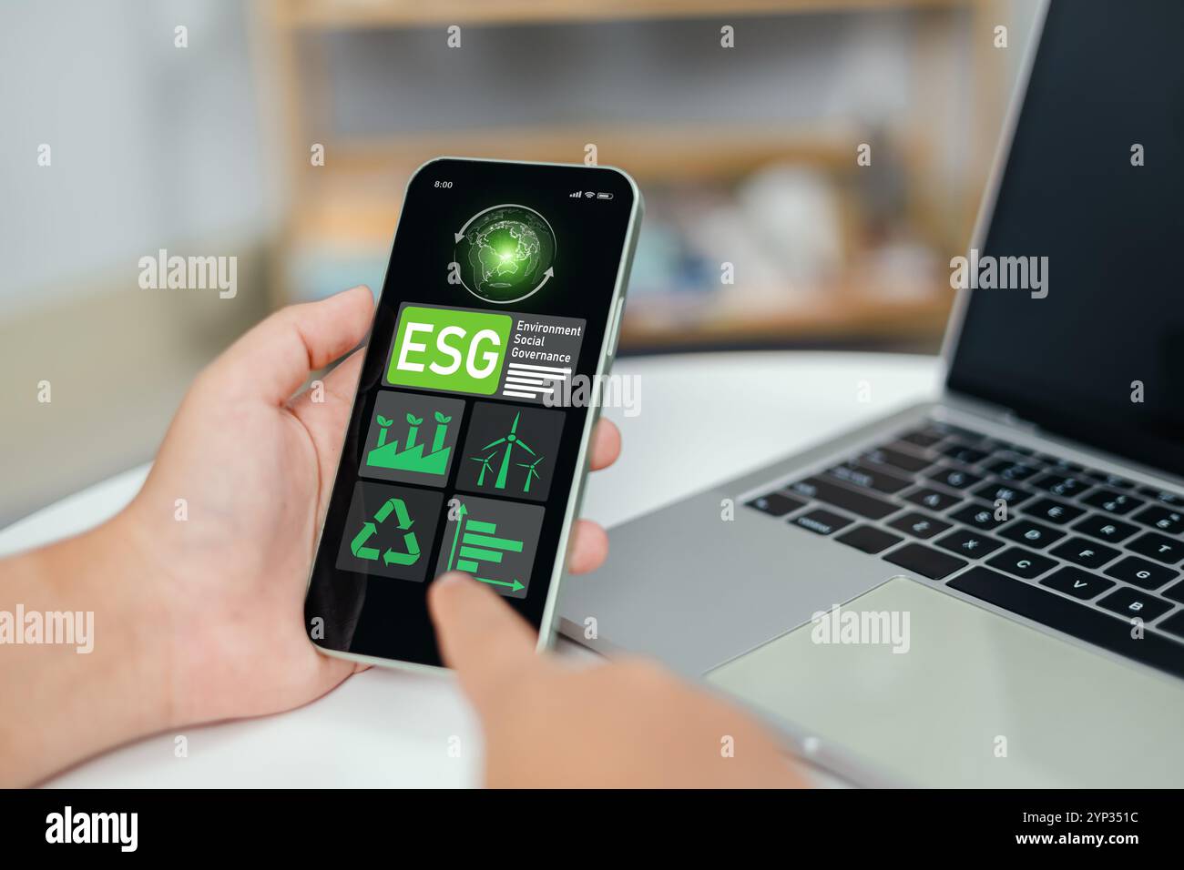 Hand mit Laptops zur Analyse von ESG auf dem Smartphone-Bildschirm in Business Investment Strategy Concept, Environment Social Governance Investment Business conc Stockfoto