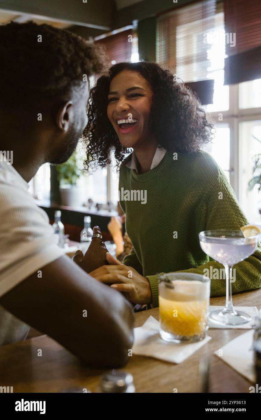 Glückliche junge Frau genießt das Date mit einem Freund in der Bar Stockfoto