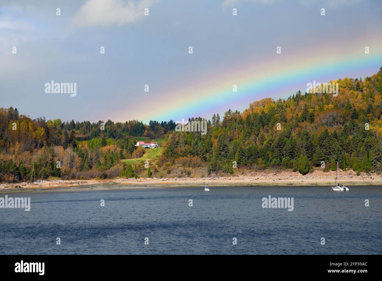 Brillanter Regenbogen über den Gewässern von Saguenay, Quebec und wunderschöne Herbstfarben. Stockfoto