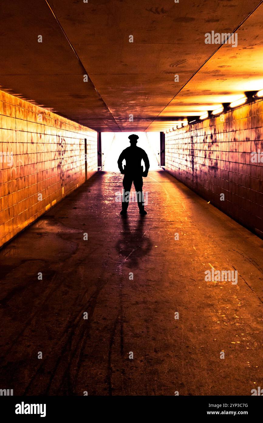 Polizist, der in einem Tunnel oder einer Unterführung steht Stockfoto