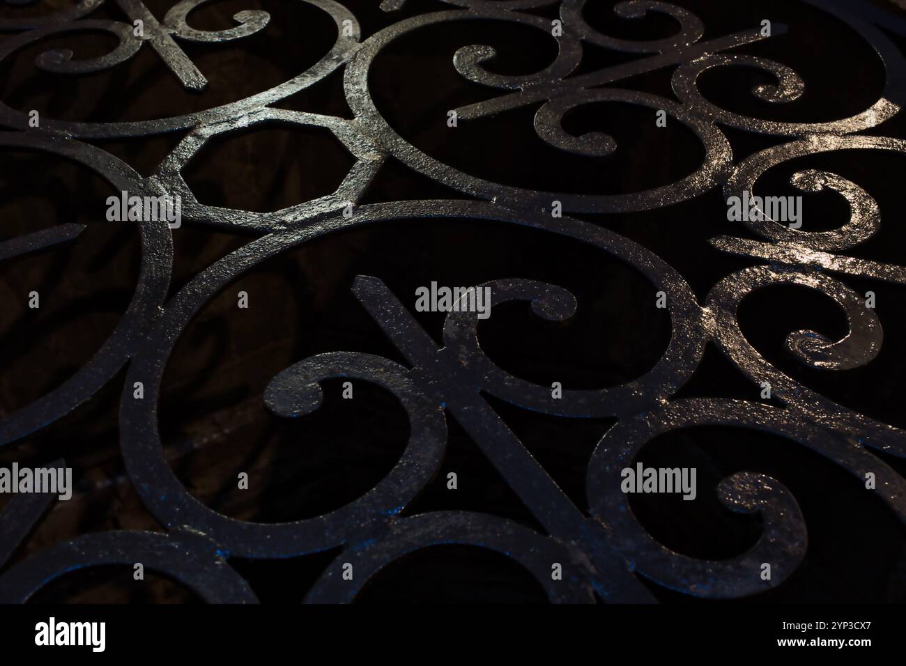 Nahaufnahme eines schmiedeeisernen Gitters, der einen Brunnen in einem alten Gebäude in Siena schützt Stockfoto