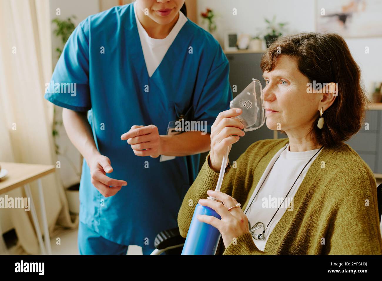 Ältere Frau, die Atemgeräte benutzt, während sie Hilfe von medizinischem Fachpersonal in häuslicher Umgebung erhält Stockfoto