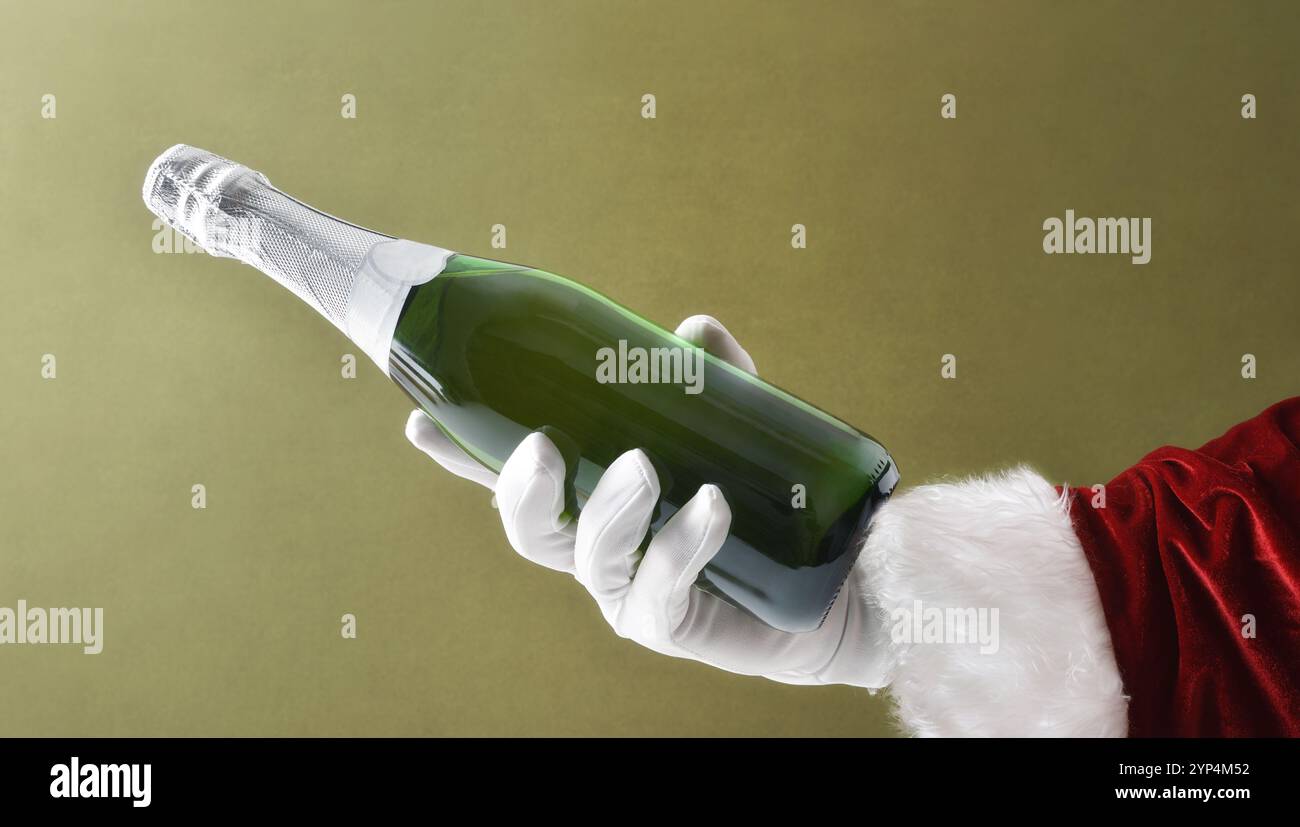 Weihnachtsmann Hand in Anzug und Handschuhe mit einer Flasche Sekt auf grünem isoliertem Hintergrund. Stockfoto