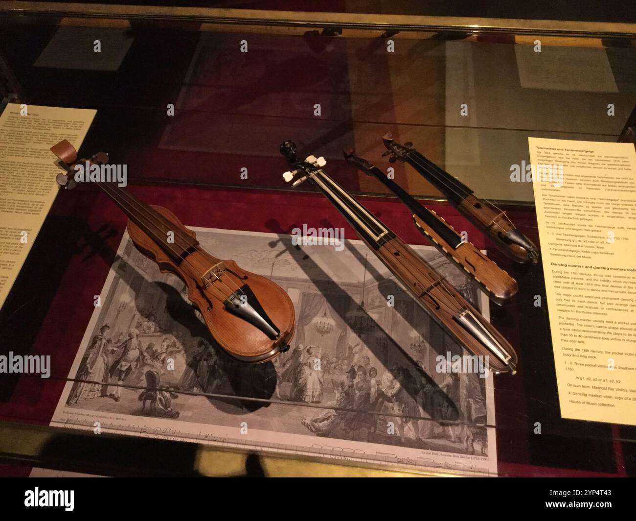 Eine Sammlung historischer Saiteninstrumente, die in einem Museum ausgestellt werden, zeigt ihre einzigartigen Designs. Die Ausstellung lädt Besucher ein, die Evolut zu erkunden Stockfoto