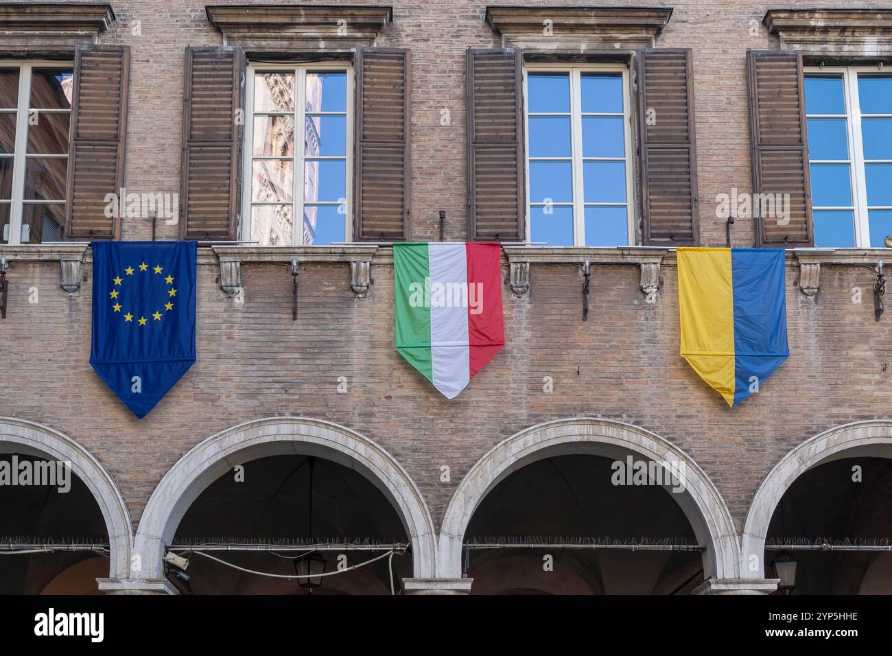 Europäische, italienische und ukrainische Flaggen. Solidarität und Unterstützung für die Ukraine. Russische Invasion. Rathaus. Piazza Grande, Modena, Italien, Europa, EU Stockfoto