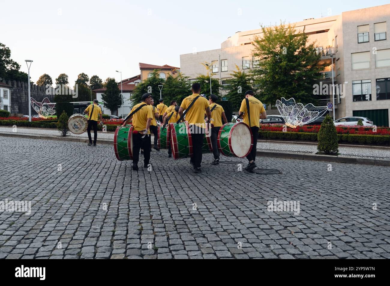 Traditionelle Trommler in gelben Uniformen marschieren während der Stadtfeste durch die kopfsteingepflasterten Straßen von Guimarães Stockfoto