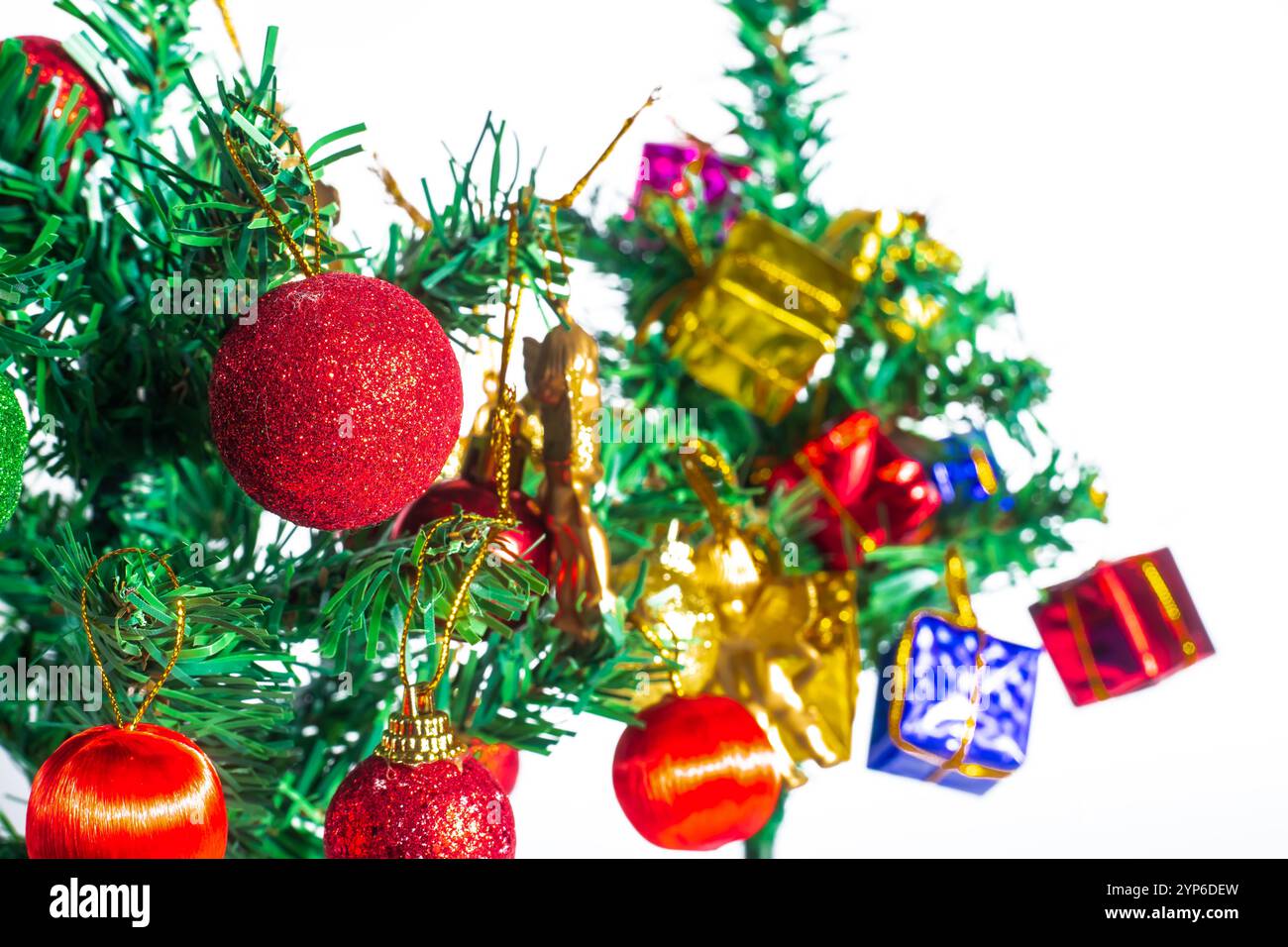Ein wunderschön dekorierter Weihnachtsbaum mit lebendigen Ornamenten und Geschenken, vor einem sauberen weißen Hintergrund. Stockfoto