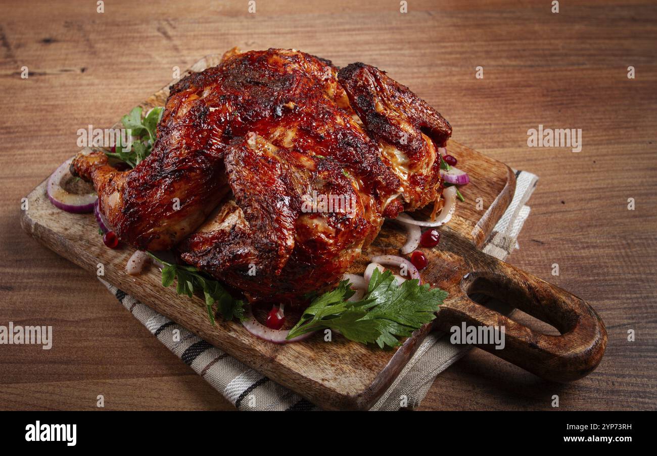 Ganze gebratene Hühnchen mit Gewürzen, gegrilltes Hühnchen, auf einem Schneidebrett, Blick von oben, hausgemacht, keine Leute Stockfoto