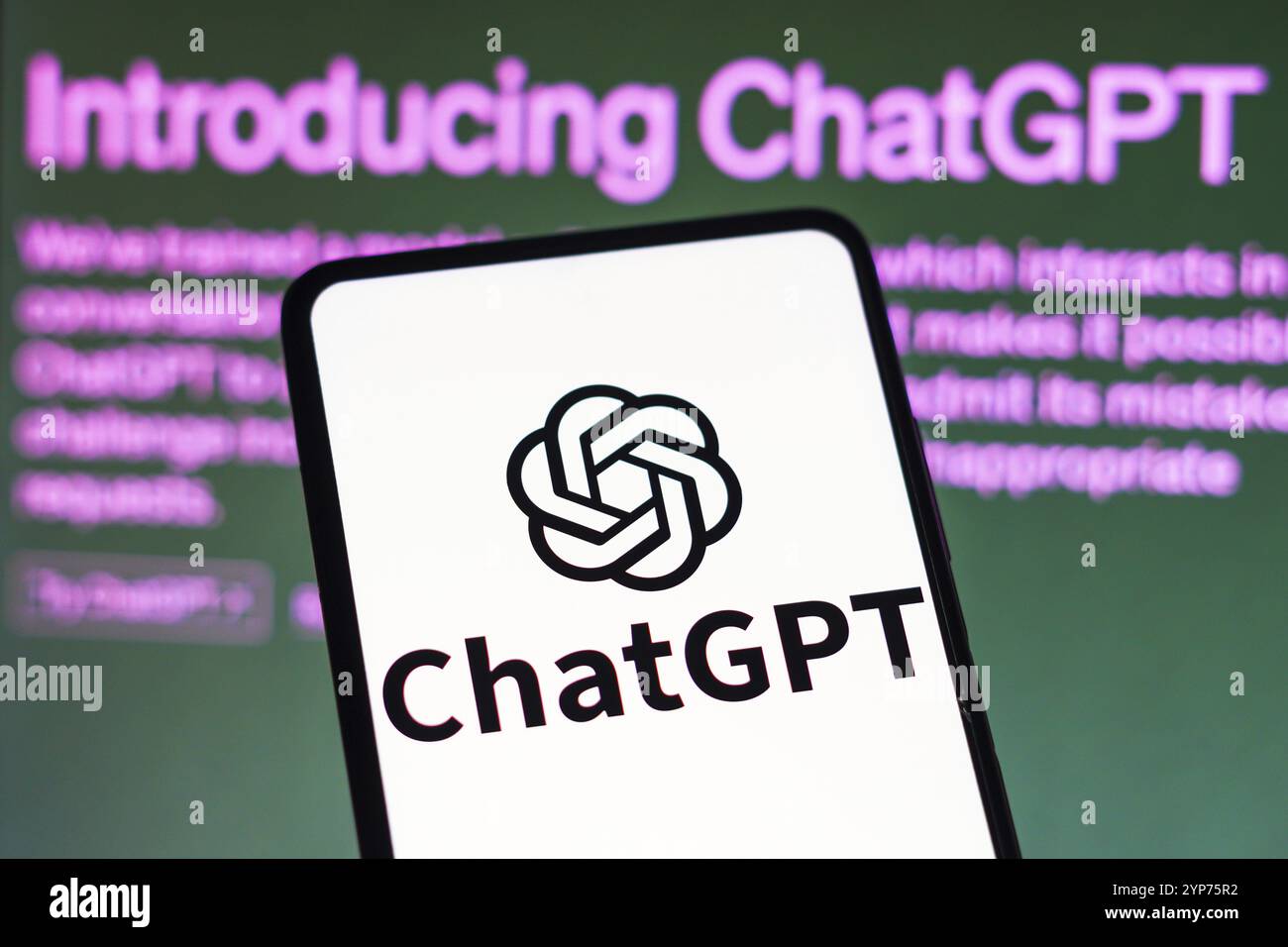 In dieser Fotoabbildung wird das ChatGPT-Logo auf einem Smartphone und im Hintergrund auf der Seite mit Einführung von ChatGPT angezeigt Stockfoto