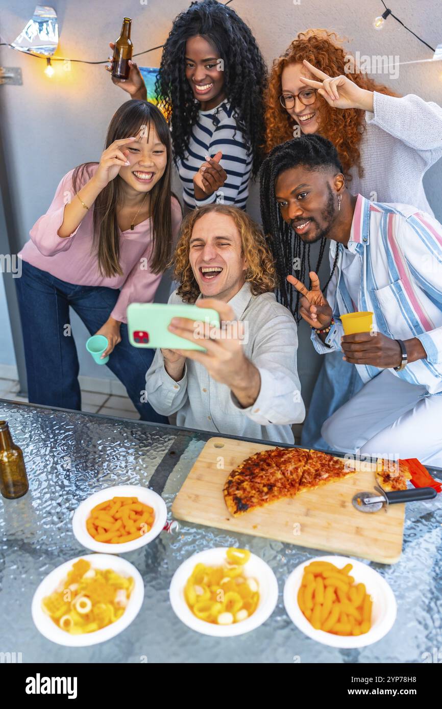 Vertikales Foto einer Gruppe von multiethnischen glücklichen Freunden, die Selfie auf einer Dachparty machen Stockfoto